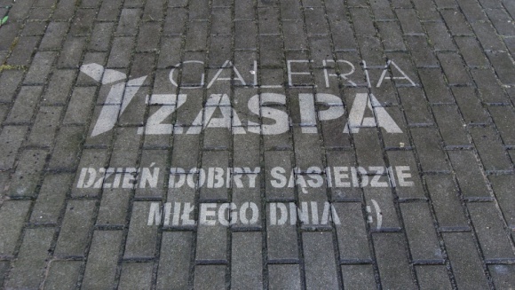 Galeria Zaspa wita się z sąsiadami ekologicznym graffiti BIZNES, Handel - „Dzień dobry sąsiedzie. Miłego dnia!” – między innymi takie napisy na chodnikach codziennie witają mieszkańców dzielnicy Zaspa.